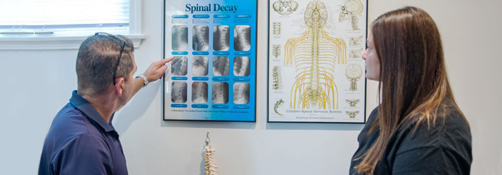 Chiropractor Milford CT Matthew Paterna With Patient Explaining Spinal Decay